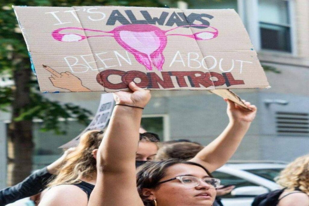 Woman at a protest ground advocating for birth control rights and abortion laws.