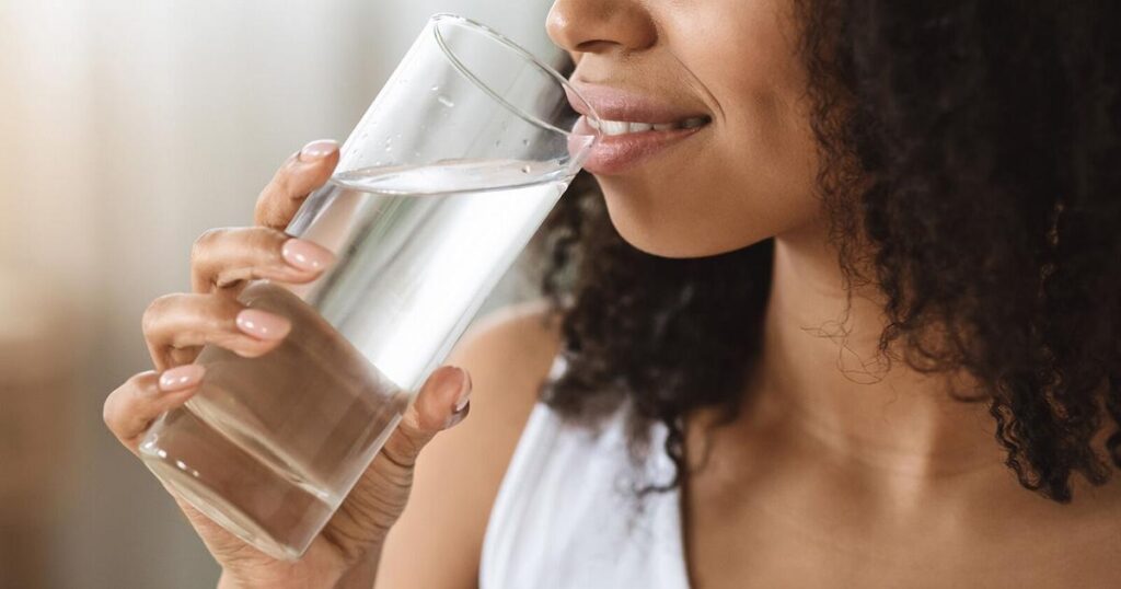 A Picture of a  Woman Drinking Water Containing PFAS