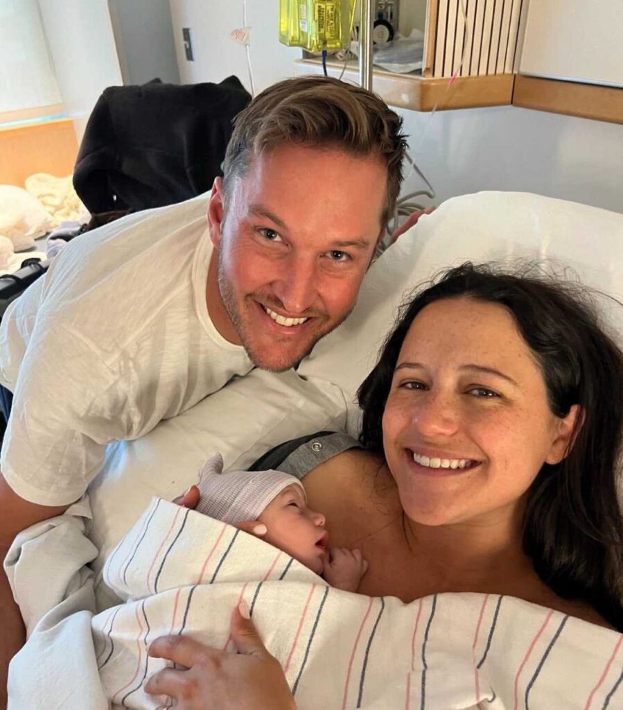 A picture of Elinor Monahan and husband holding their newborn