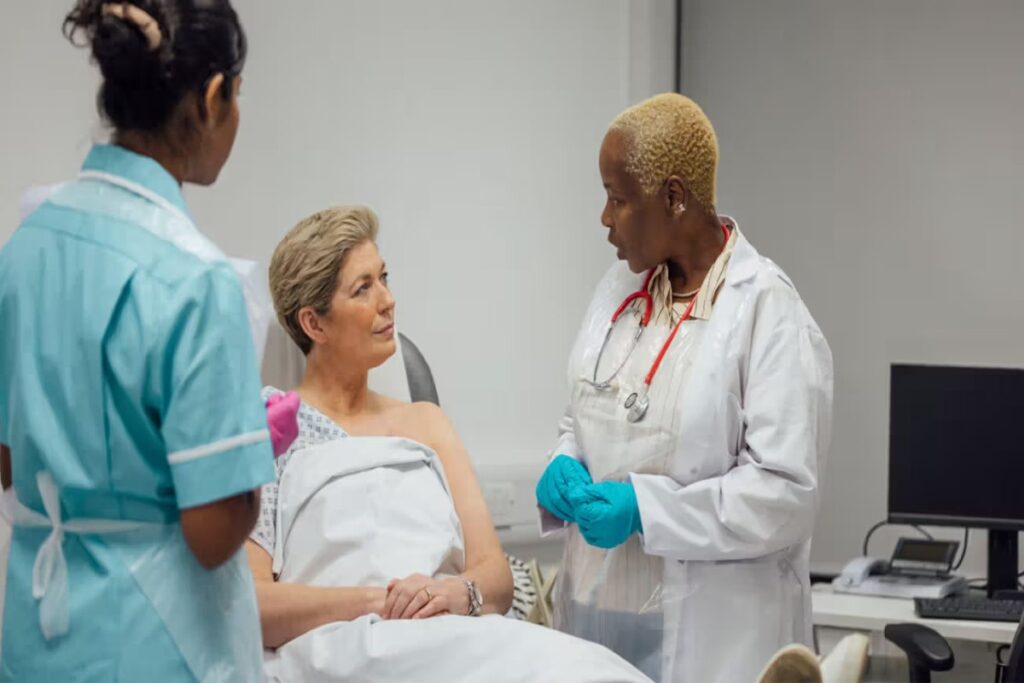 A Picture of a Woman and Healthcare providers During Breast Cancer Examination