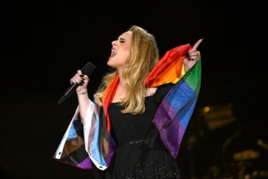 A picture of Adele with the pride flag around her shoulders