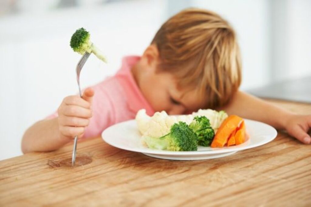 A picture of a child refusing to eat vegetables