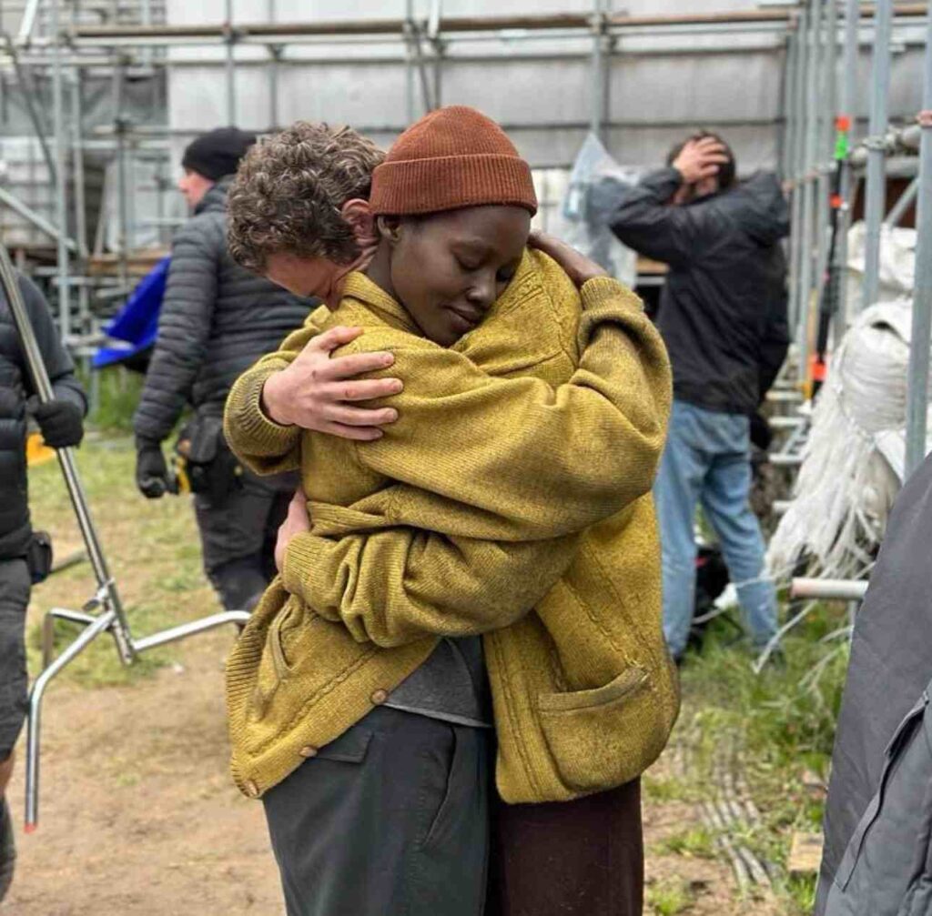 Lupita Nyong'o hugging a cast member behind the scenes of "A Quiet Place: Day One"