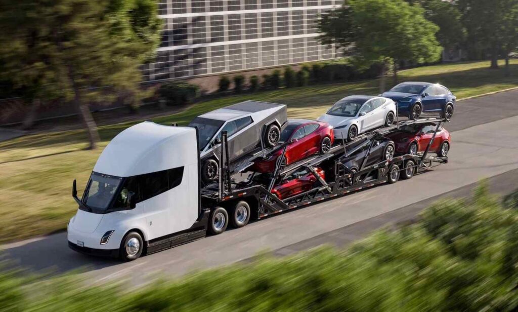 A bunch of Tesla cars been moved by a tesla trailer