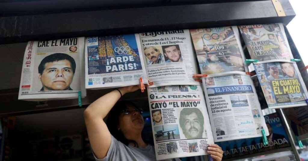 A woman hangs up newspapers on a line