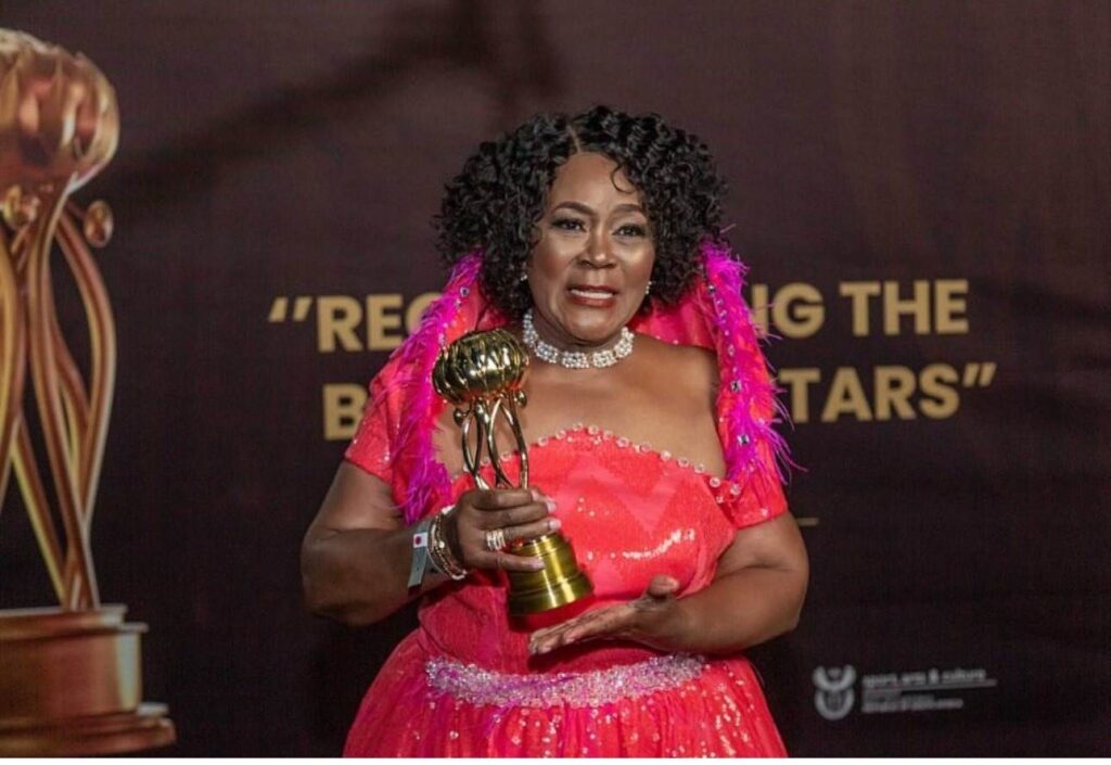 Connie Chiume holding an award