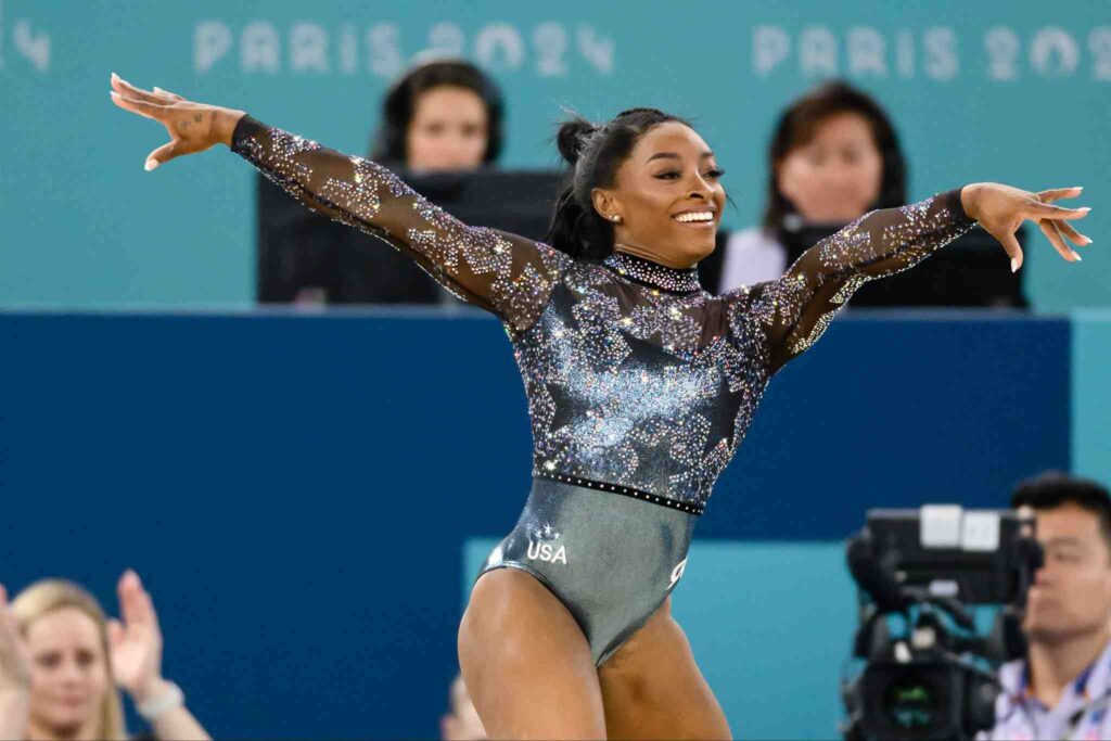 Simone Biles in a leotard posing for the crowd