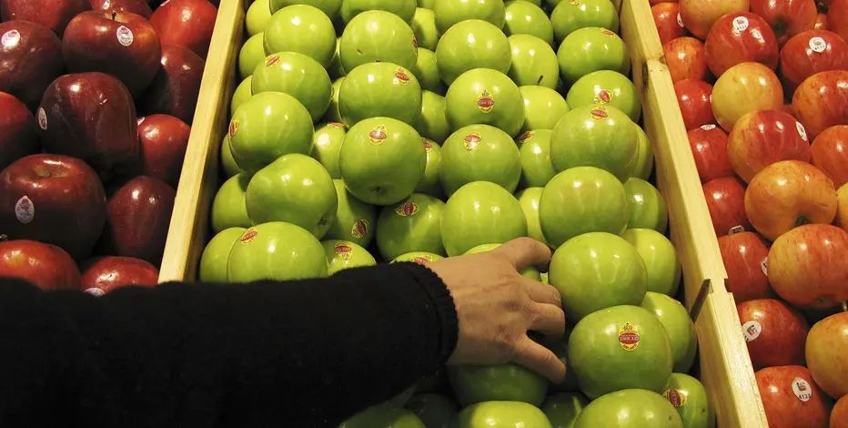 A Picture of a man selecting apples