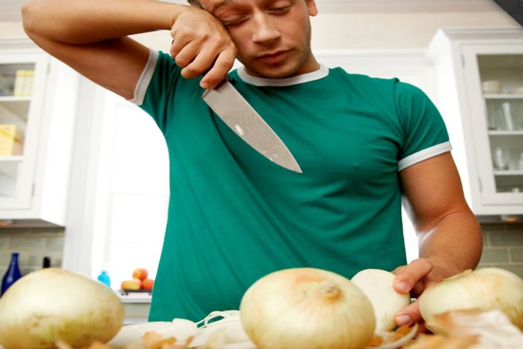 A Picture of a Man Cutting Onions