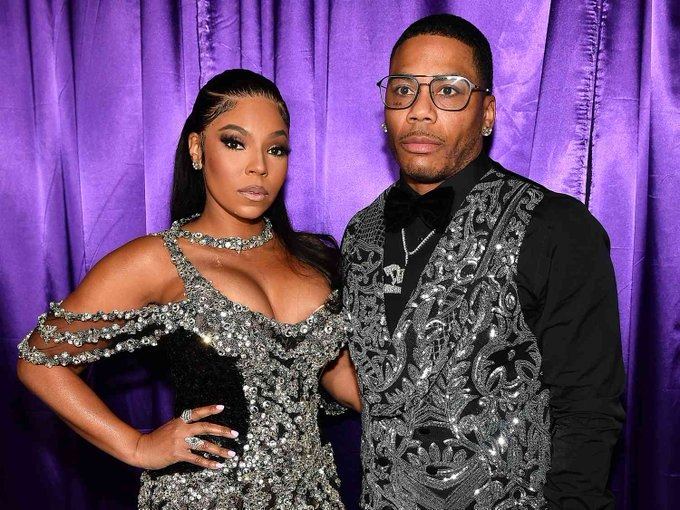 Ashanti and Nelly posing in matching numbers