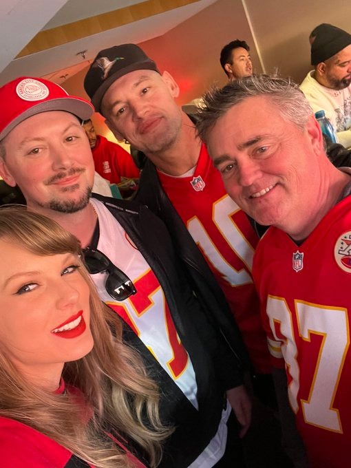 Taylor Swift posing with Baron Corbin and others at a game