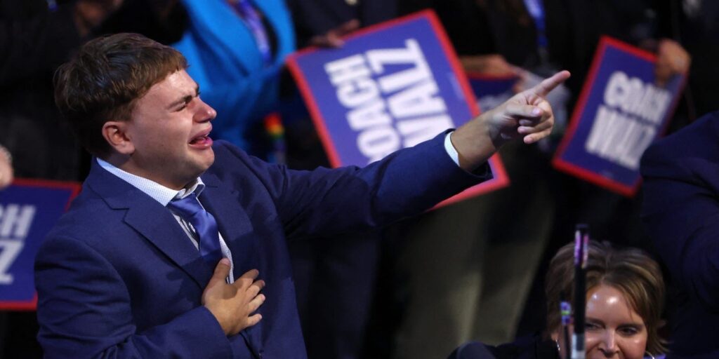 Tim Walz's son Gus pointing at his father with tears in his eyes at the DNC