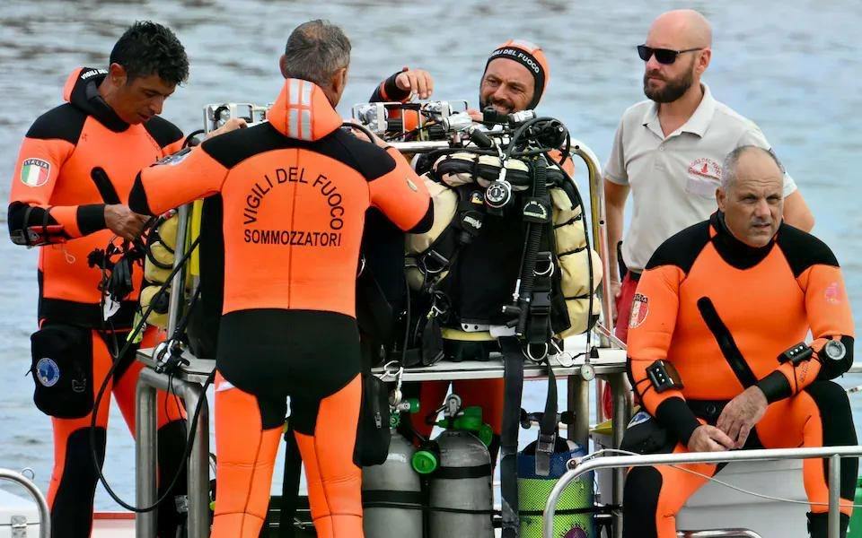 A team of divers handling diving equipment