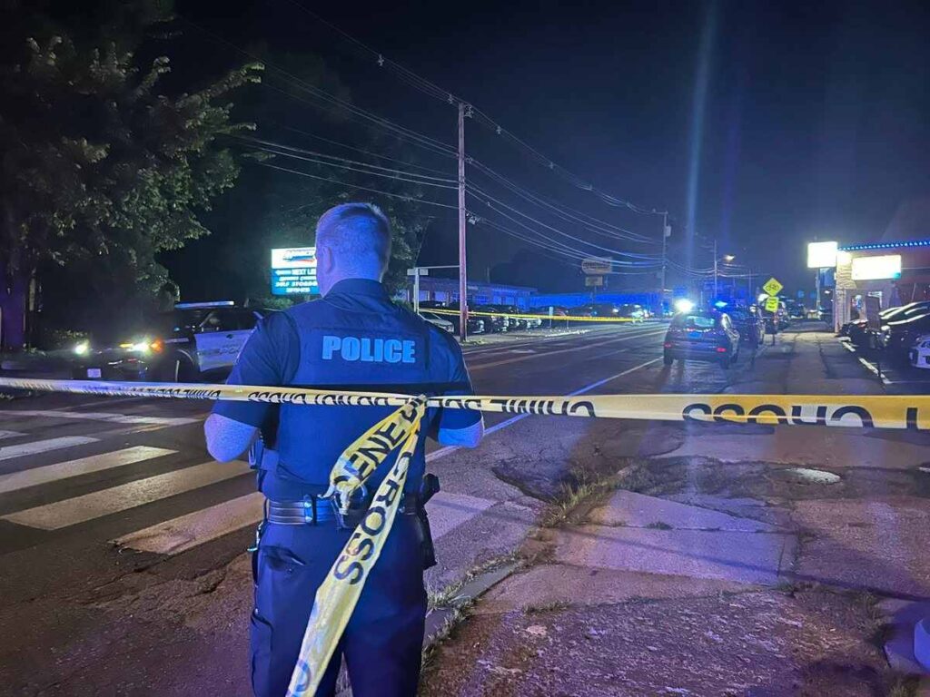 A policeman standing behind a police tape