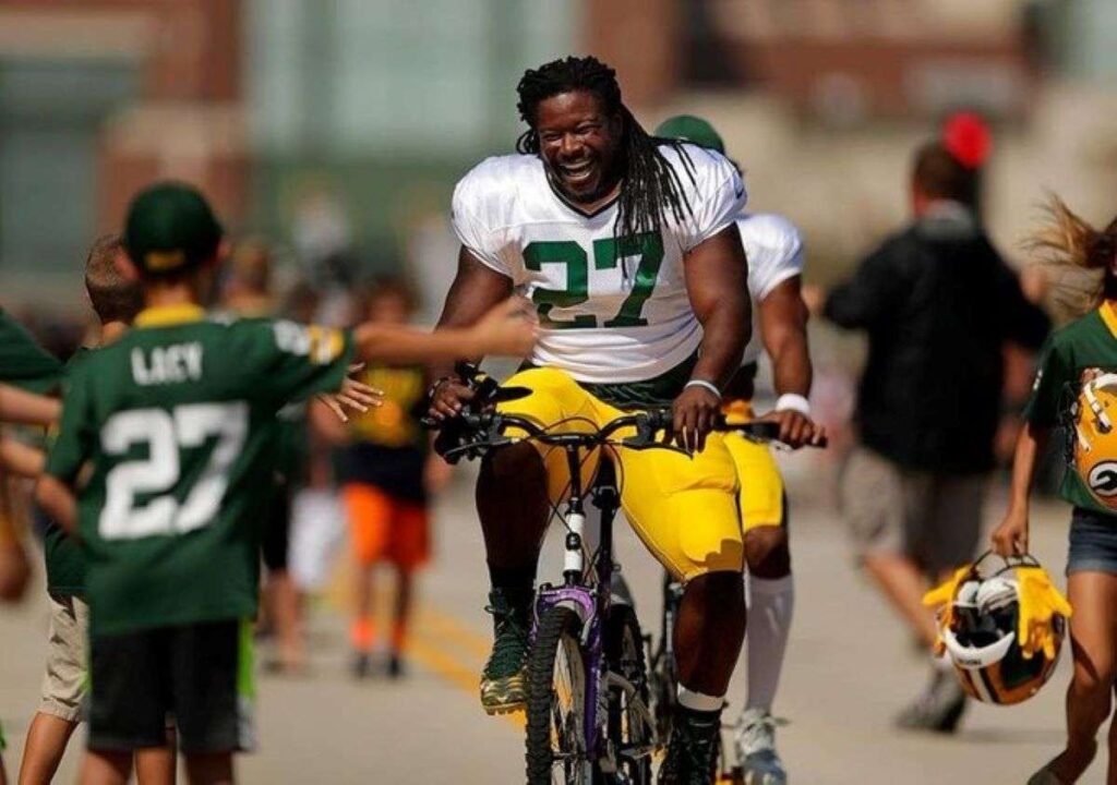 Eddie Lacy riding a bicycle in full sport gear